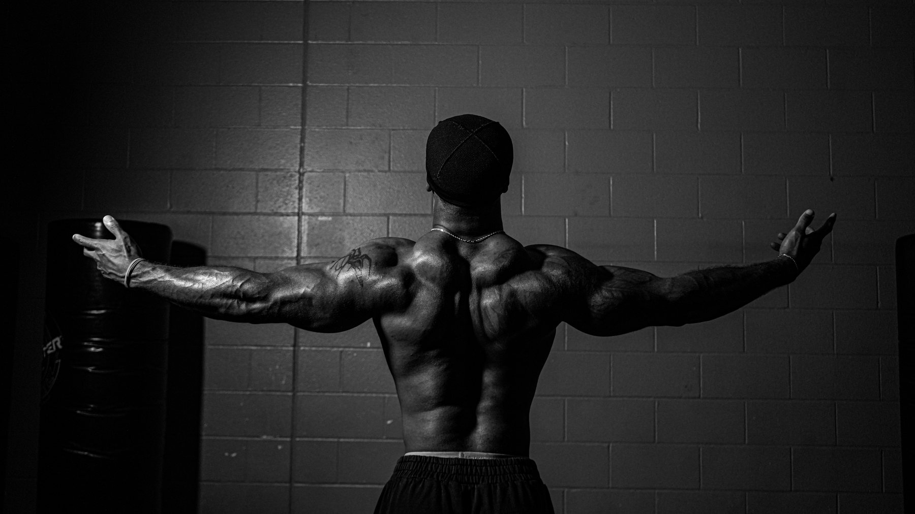 Edward Banks from behind, arms spread, black and white